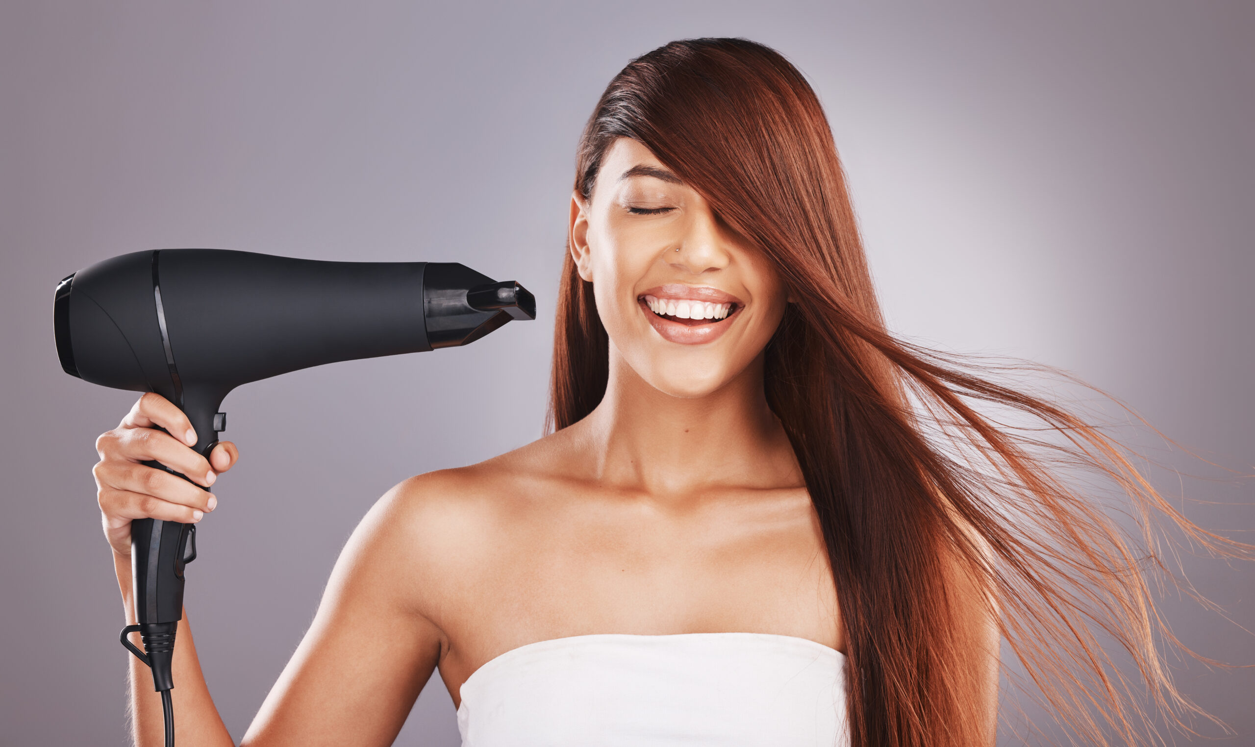 Beauty, hairdryer and woman salon smile, happy and excited isolated against studio gray background